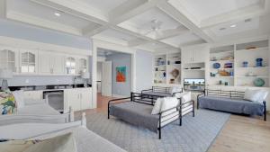 Una sala de estar con dos camas y una cocina. en 114 Ocean Boulevard by AvantStay Beachfront Infinity Pool Basketball Court Recently Renovated, en Sullivans Island