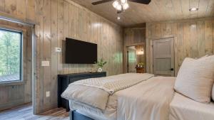 Una televisión o centro de entretenimiento en Luxe Cabin w Hot Tub Views Game Room – Sleeps 10 Do Good Holler by AvantStay