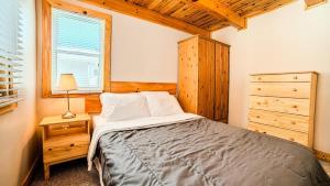 a bedroom with a bed and a dresser and a window at #90 Lakefront 3-bdrm Chalet in Muskoka in Port Carling +20 photos