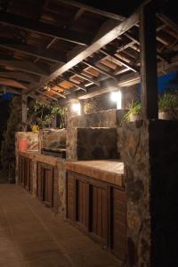 an outdoor bar with a stone wall and lights at Tierra Mia Hacienda Ruta del Vino in Valle de Guadalupe