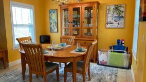 Coral Garden by AvantStay Great Location w Balcony Shared Pool في ستوك آيلاند: غرفة طعام مع طاولة وكراسي خشبية