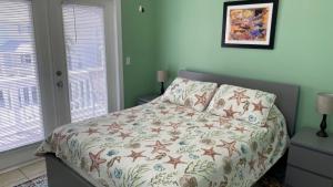 Coral Garden by AvantStay Great Location w Balcony Shared Pool في ستوك آيلاند: غرفة نوم مع سرير مع لحاف و نافذتين +26 صورة