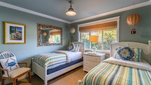 Un dormitorio con dos camas y un espejo y una silla. en Truly a Treasure by AvantStay Walk to Beach Patio, en Manzanita