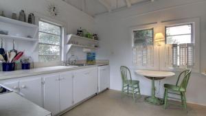 Una cocina con gabinetes blancos y una mesa y sillas. en 1111 Middle Street by AvantStay Charming Historic Cottage Featured in Dear John Movie Beach Access, en Sullivans Island 16 fotos más