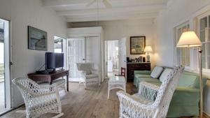 Una sala de estar con un sofá y sillas y un televisor. en 1111 Middle Street by AvantStay Charming Historic Cottage Featured in Dear John Movie Beach Access, en Sullivans Island