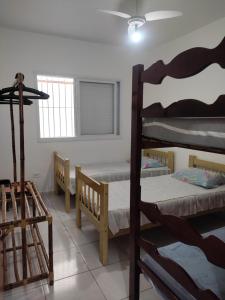 a room with three bunk beds and a window at Casa Praia Arpoador in Peruíbe