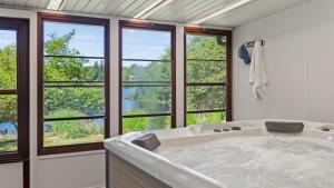 Simply Shores by AvantStay Private Beach Dock Lake Overlook في Long Pond: حوض استحمام كبير في غرفة بها نوافذ +79 صورة