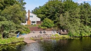 Simply Shores by AvantStay Private Beach Dock Lake Overlook في Long Pond: اطلالة جوية على منزل بجانب بحيرة