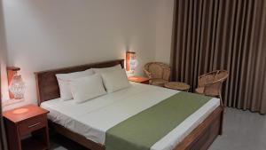 a bedroom with a bed and a table and chairs at The Clouds Ahangama in Ahangama