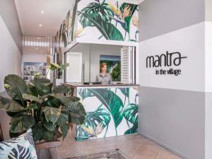 Una mujer está parada en el vestíbulo de un salón. en Mantra in the Village, en Port Douglas 43 fotos más