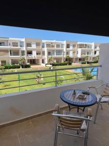 a patio with a table and chairs on a balcony at 2BR Beach Apt, Pool, Luxury place in Mansouria