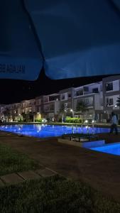 a swimming pool with blue lights in front of a building at 2BR Beach Apt, Pool, Luxury place in Mansouria