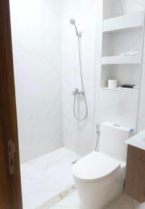 a white bathroom with a shower and a toilet at 2BR Beach Apt, Pool, Luxury place in Mansouria +3 photos