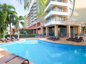 a swimming pool in front of a building at Mantra on The Esplanade in Darwin