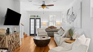 Una sala de estar con muebles blancos y un ventilador de techo. en Coastal Soul 393 by AvantStay Near Boat Ramp Bay Private Yard, en Santa Rosa Beach