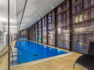 a large swimming pool in a building with windows at Peppers Waymouth Hotel in Adelaide