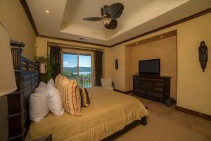 een slaapkamer met een bed, een televisie en een raam bij Montebello 1C - 3 bdr 3 bath Ocean view in Isla Herradura