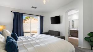 a bedroom with a large white bed and a bathroom at Pacifica Sur by AvantStay Pool Hot Tub Gazebo in Indio +27 photos