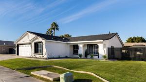 a white house with a hose in a yard at Pacifica Sur by AvantStay Pool Hot Tub Gazebo in Indio