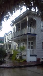 a large white house with a porch and balcony at Cornerstone West Lower Unit in Savannah