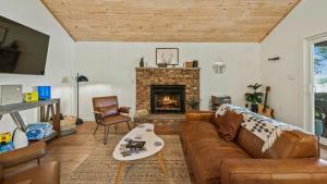 a living room with a couch and a fireplace at Lake Daze by AvantStay Lakefront w Modern Interior Enclosed Porch Hot Tub in Long Pond