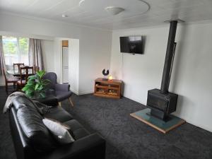 a living room with a couch and a wood stove at Accessible Respite House in Whangarei