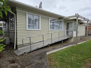 a mobile home with a porch and a railing at Accessible Respite House in Whangarei