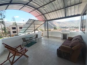 a living room with a couch and a table on a balcony at Hostal Ayllu con cochera in Urubamba