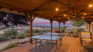 a patio with a table on a wooden deck at Olive Ranch by AvantStay Enjoy Sunsets over the Valley 4.5 Acre Ranch Home in Paso Robles