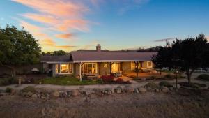 a house with its lights on in the sunset at Olive Ranch by AvantStay Enjoy Sunsets over the Valley 4.5 Acre Ranch Home in Paso Robles