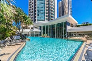 a swimming pool in front of a building with tall buildings at Stunning Oceanview - Beachfront hotel suite in Gold Coast