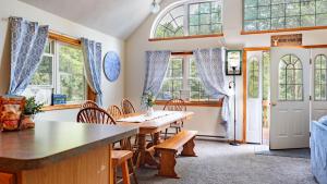 a dining room with a table and chairs and windows at The Nest at Brier Crest by AvantStay Game Room Expansive Deck Fire Pit in Blakeslee