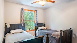 two beds in a bedroom with a window at The Nest at Brier Crest by AvantStay Game Room Expansive Deck Fire Pit in Blakeslee