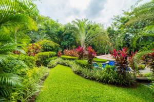 um jardim com plantas e árvores verdejantes em Veranda 1E 3bdr 3 bath em Isla Herradura mais 29 fotografias