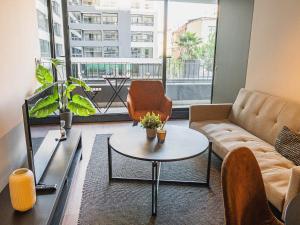 a living room with a couch and a table at HOM I Lujoso Depto 2D2B, Ñuñoa con Estacionamiento in Santiago