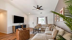 a living room with a couch and a flat screen tv at Montego by AvantStay Private Yard w Pool Hot Tub in Indio