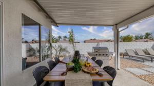 a patio with a table and chairs and a grill at Montego by AvantStay Private Yard w Pool Hot Tub in Indio