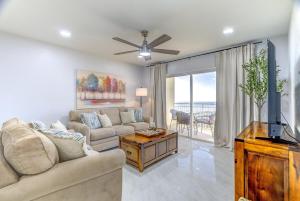 een woonkamer met een bank en een tv bij Madeira Norte Beachfront Condo - Walk To John's Pass in St Pete Beach