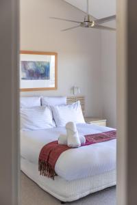 una cama blanca con un animal de peluche sentado en ella en Adina Vineyard, en Lovedale 43 fotos más