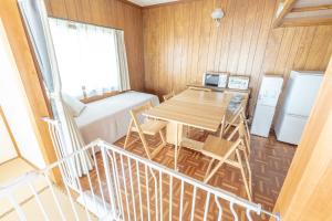 a small room with a table and a bed at よんなーハウス in Kameoka