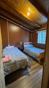 un dormitorio con dos camas en una habitación en Cabaña la percha II, en Coyhaique