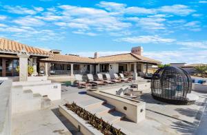 a house with a patio with chairs and a bird cage at Casa Brooks in Cabo San Lucas