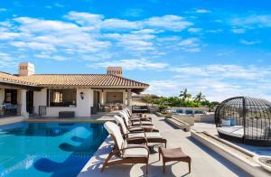 a row of chairs sitting next to a swimming pool at Casa Brooks in Cabo San Lucas