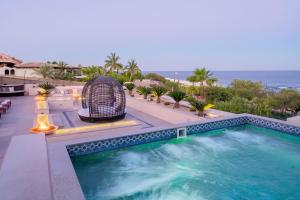 a swimming pool on top of a building with the ocean at Casa Brooks in Cabo San Lucas +33 photos