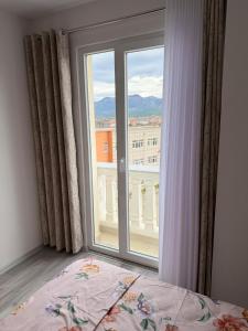 Modern 2-Bed Near Tirana and Airport with Balconies في Kamëz: غرفة نوم مع نافذة كبيرة وسرير