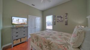 a bedroom with a bed and a dresser and a television at Shared Resort-Style Pool Playground Patio w Bar Tidal Times by AvantStay in Port Aransas +43 photos