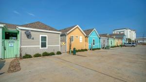 a row of colorful houses in a parking lot at Shared Resort-Style Pool Playground Patio w Bar Tidal Times by AvantStay in Port Aransas