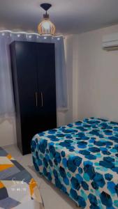 a bedroom with a bed and a black cabinet at Mar e sol residencial 2 quartos com ar condicionado,500 metros da praia de Jacumã in Conde +26 photos