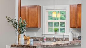 Una encimera de cocina con un fregadero y una ventana. en Chalet on Chalet by AvantStay Bright Cabin w Deck Fire Pit Near Lake, en Lake Harmony