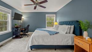 Dormitorio azul con cama y escritorio en Chalet on Chalet by AvantStay Bright Cabin w Deck Fire Pit Near Lake, en Lake Harmony